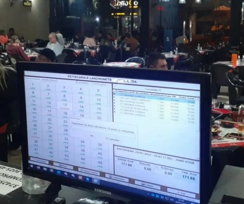 Sistema Techsoft FOODS rodando no caixa de uma petiscaria com o salão cheio à noite